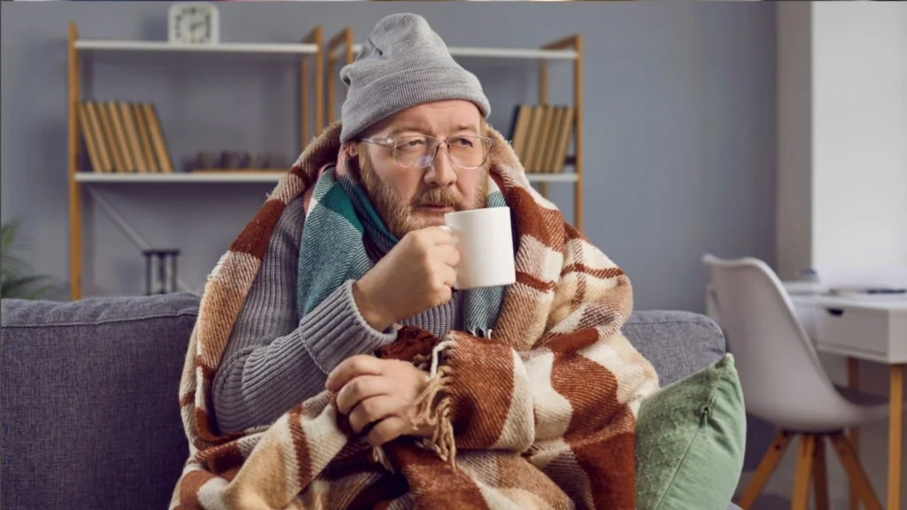 man wearing Winter clothes with blanket and a cup of coffee