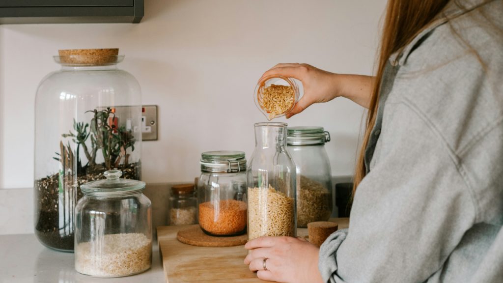 woman-standing-in-front-of-a-counter-filled-with-jars-UYr5wyAQKJU